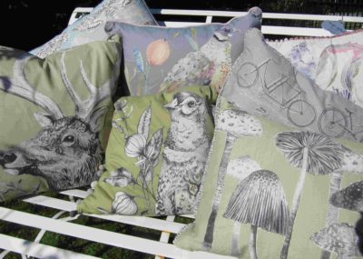 Contemporary designs of cushions in pale greens, grey and pastel colours.
